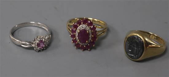 A 9ct white gold, pink sapphire and diamond cluster ring, another cluster ring and a 9ct yellow gold signet ring